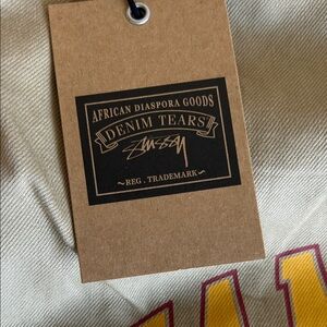 Men Denim Tears/Stussy tan shorts with yellow Jamaica crest and black logo